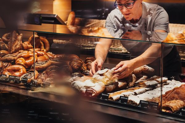 Mitarbeiterin richtet Gebäck in der Theke der Bäckerei Kurz in Galtür