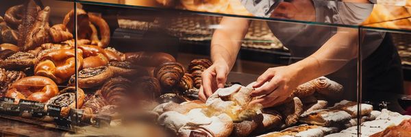 Mitarbeiterin richtet Gebäck in der Theke der Bäckerei Kurz in Galtür