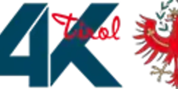 Ein Logo mit den großen, dunkelblauen Buchstaben "AK", darüber in roter, kursiver Schrift "Tirol" und rechts davon der rote Tiroler Adler mit goldenen Details auf schwarzem Hintergrund.